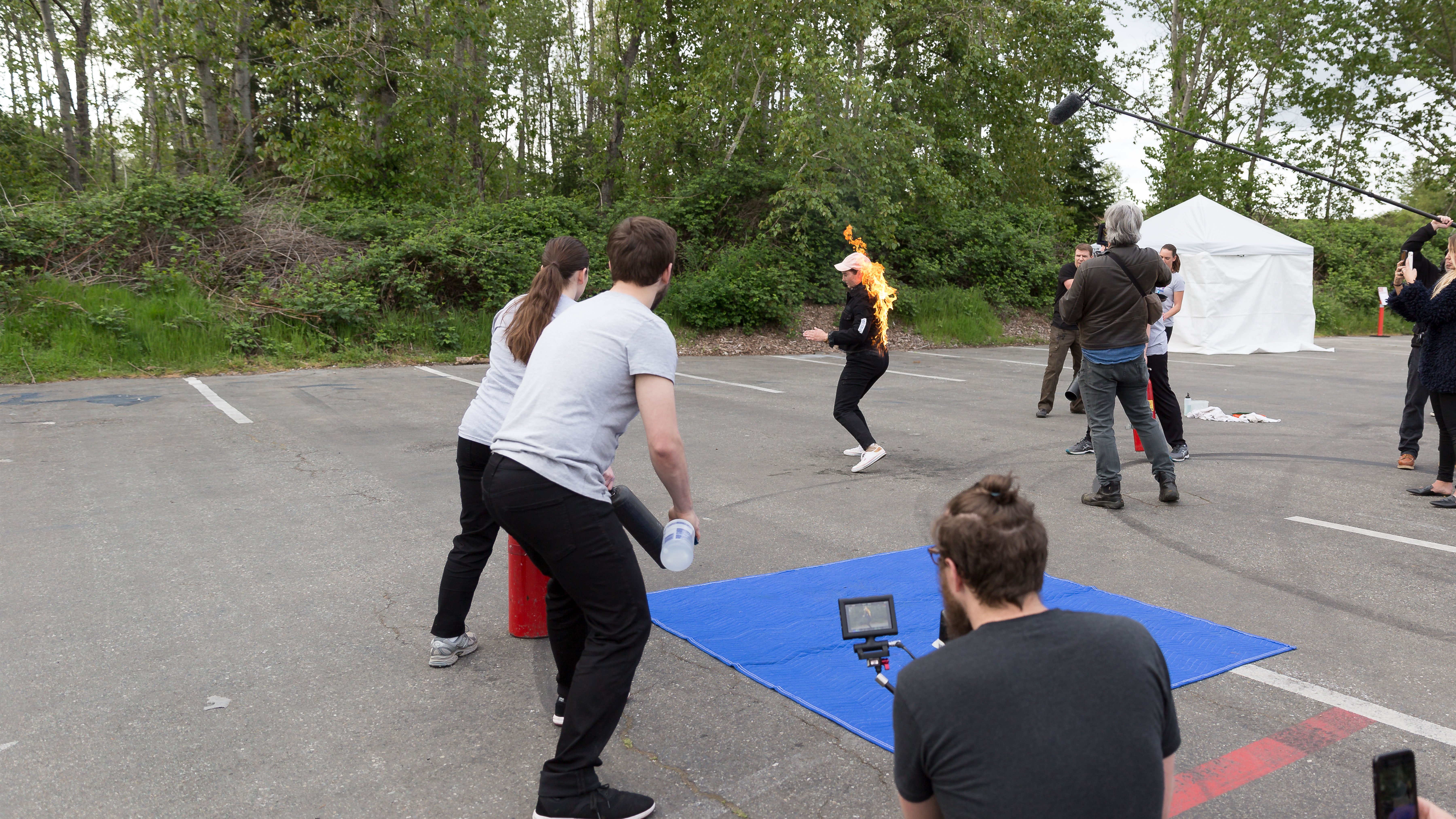 Video production crew filming a stunt school of a woman on fire