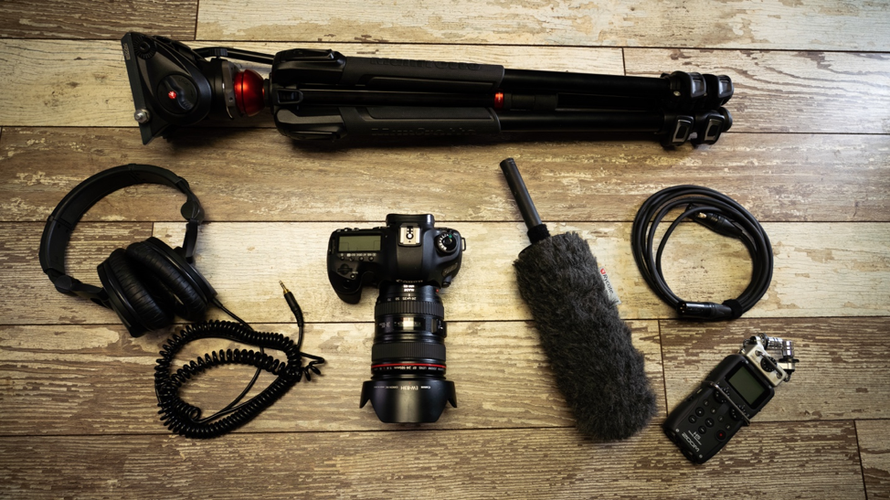 Video production equipment pack including a tripod, camera, microphone, audio recorder, headphones and audio cable