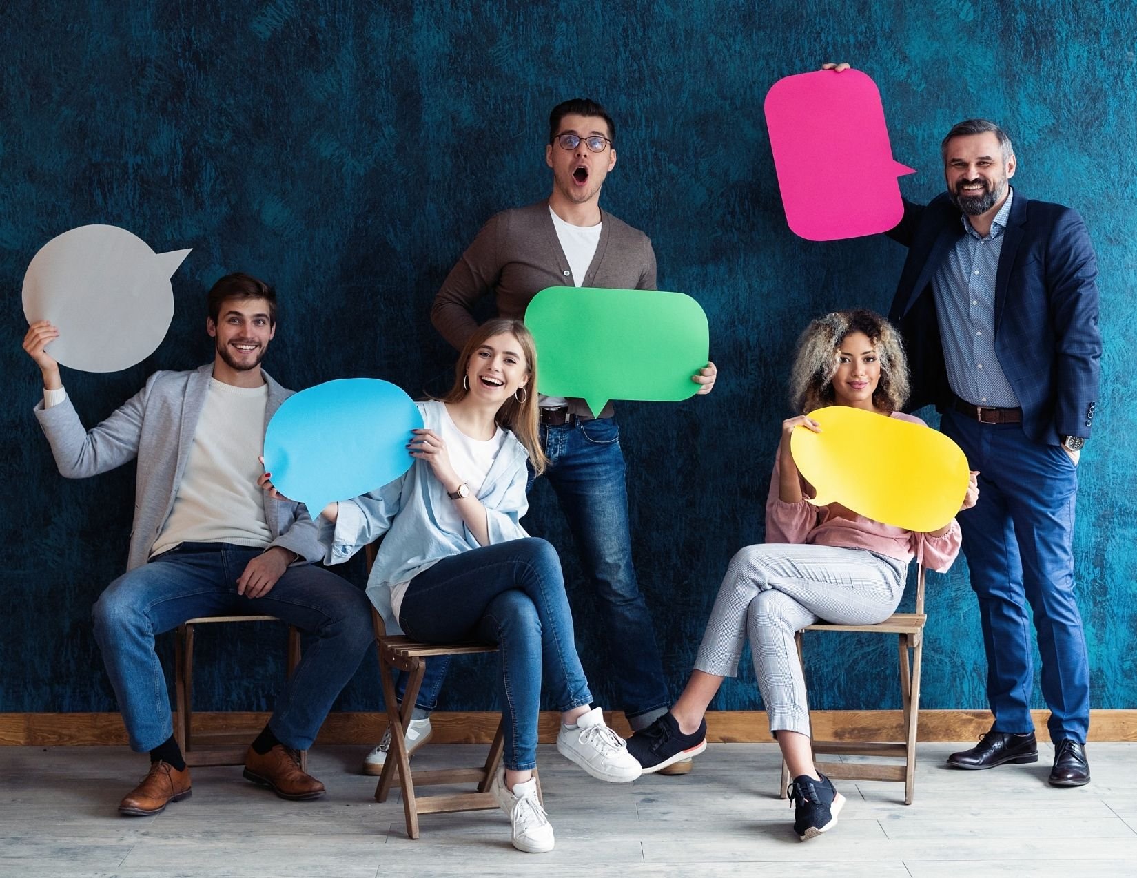 Group of people holding colored speech bubbles
