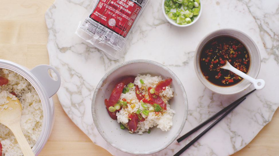 Flat lay viewpoint of a cooking station including rice, green onions, soy sauce and chopsticks