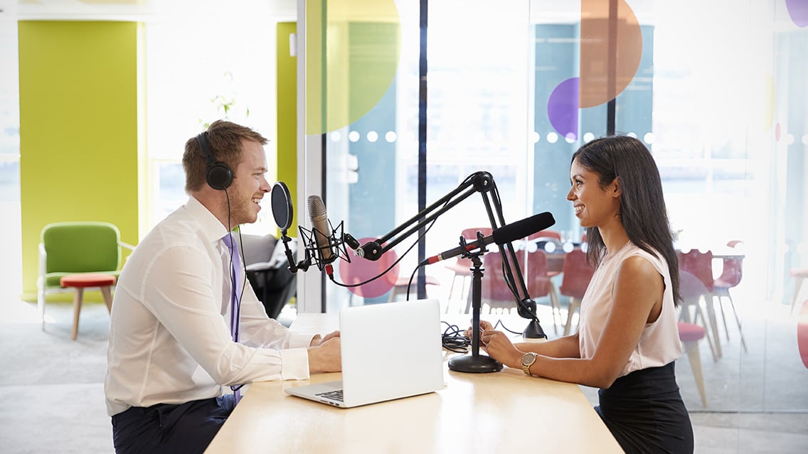 Business podcasters recording an episode in office setting