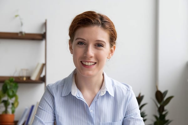 Woman smiling at webcam with a clean, white background