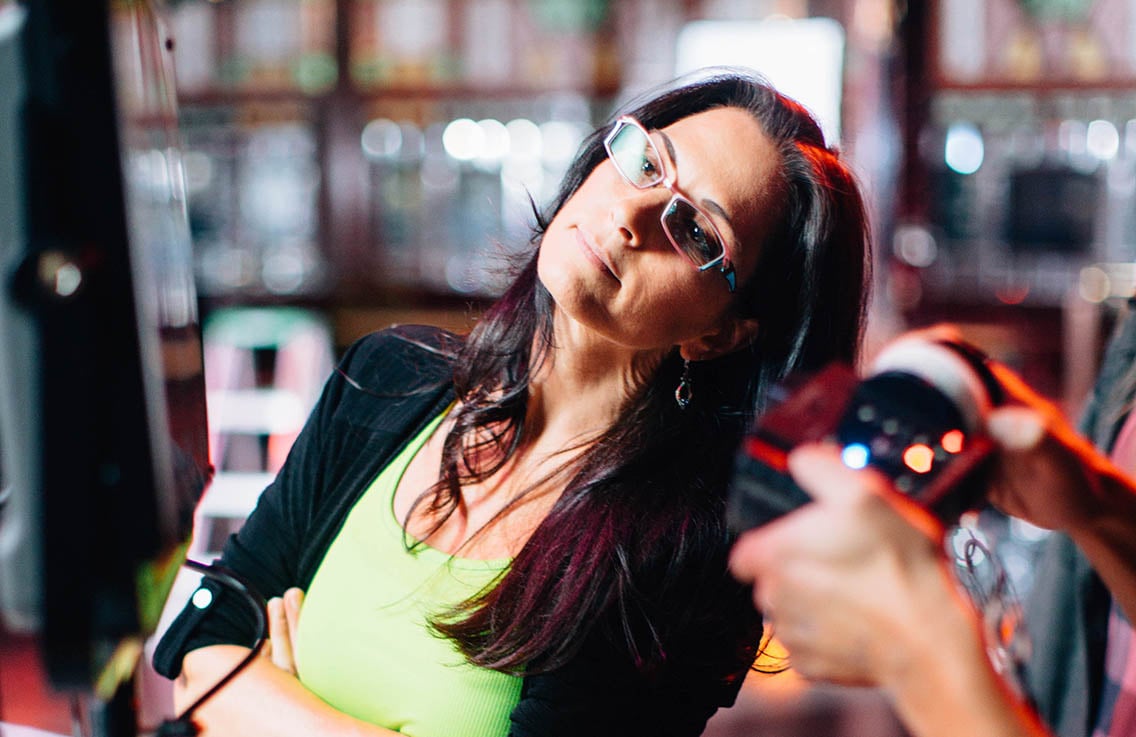 Female director wearing glasses looking inquisitive after calling action during a video production shoot