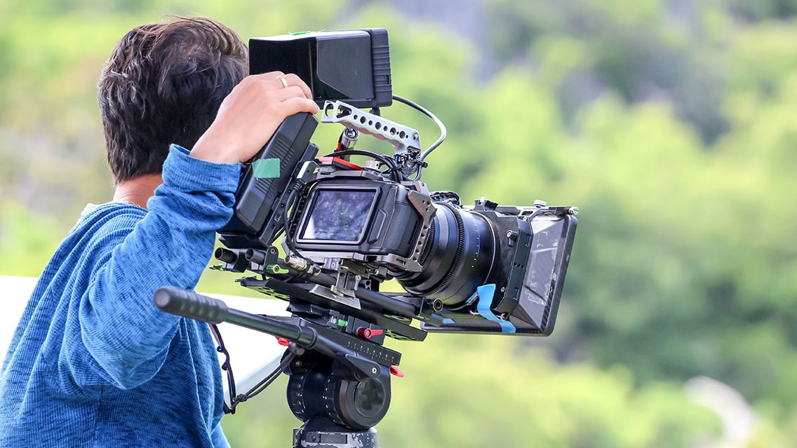 Camera operator shooting a video outside on a on-location video production set