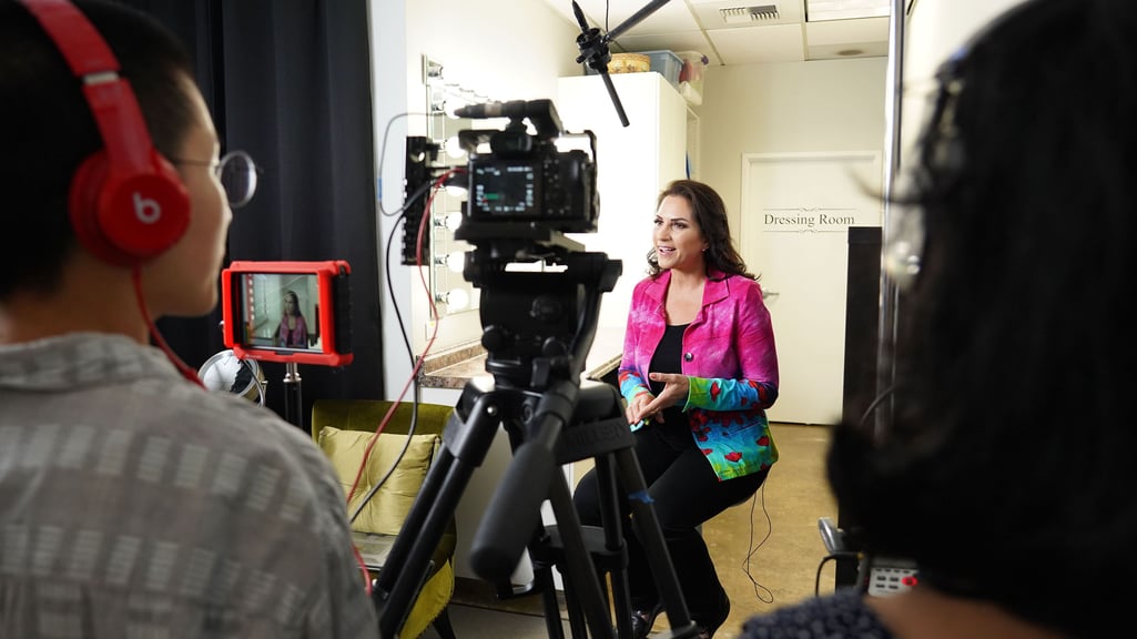 Behind the scenes look of a woman being interviewed on-camera